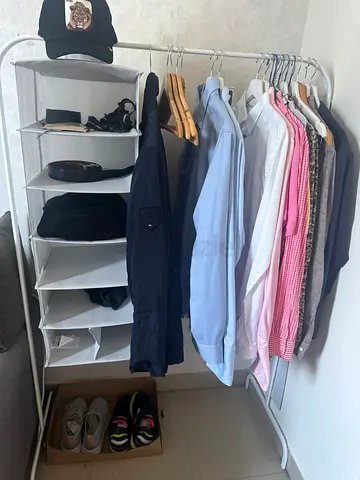 Clothing rack with assorted mens shirts, jacket and accessories