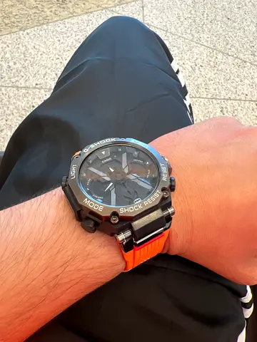 Black sport digital-analog wristwatch with orange silicone strap