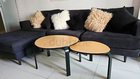 L-shaped dark grey fabric sectional sofa with 2 nesting wooden coffee tables