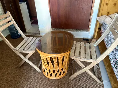 Rattan side table with glass top and two folding wooden chairs - used