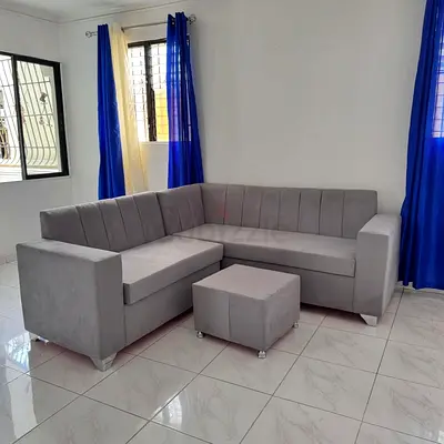 Light Grey L-Shaped Corner Sofa with Ottoman - Good Condition