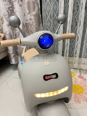 Used grey ride-on baby scooter with lights and music — perfect new condition