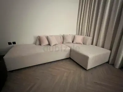 Light grey modern L-shaped sofa with cushions - good condition