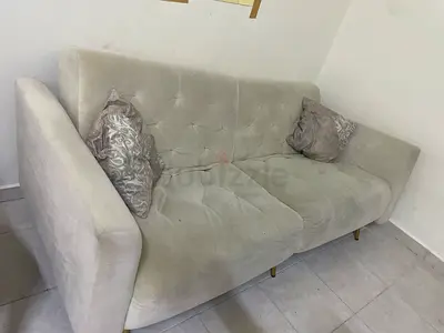 Light grey 3-seater tufted sofa with cushions.