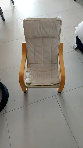 Light wooden lounge chair with cream cushion