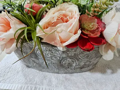 Elegant decorative floral arrangement in a stylish embossed ceramic bowl