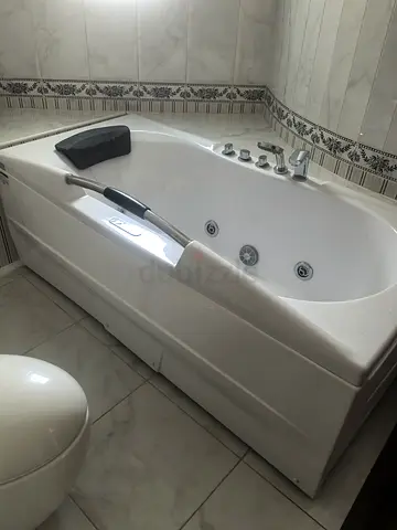 White Jacuzzi Bathtub with Jets and Headrest