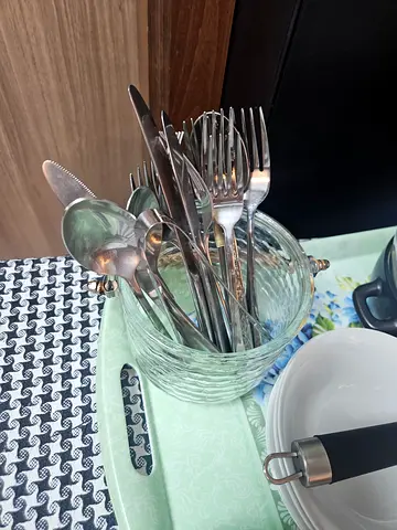 Set of everyday stainless steel cutlery in glass jar - used