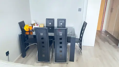 Black glass dining table with 6 high-back chairs