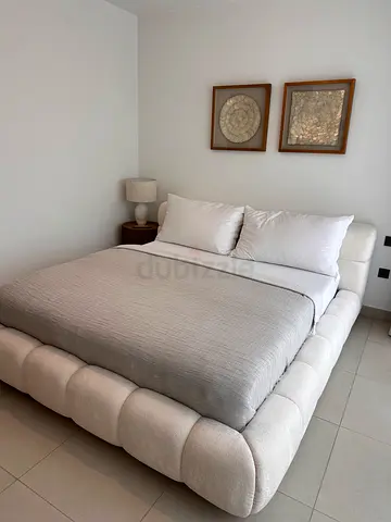 Light beige upholstered platform bed with padded frame