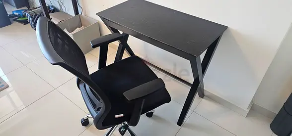 Compact black writing desk with ergonomic swivel chair - used