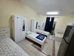 Bed space with a balcony with a fridge