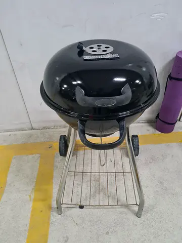 Portable charcoal kettle BBQ grill on metal stand - used