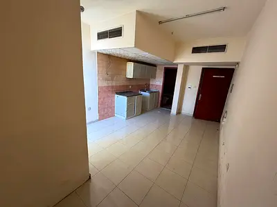For annual rent in Rawda 1, Ajman: Studio apartment with balcony, central air conditioning, and maintenance included. Prime location next to Sheikh Am