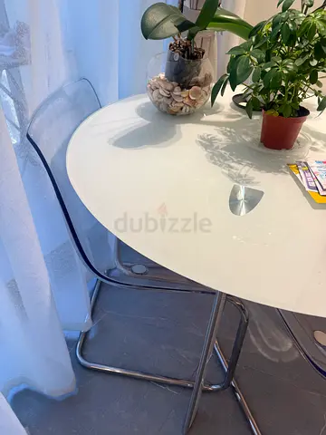 Round white glass dining table with chrome legs