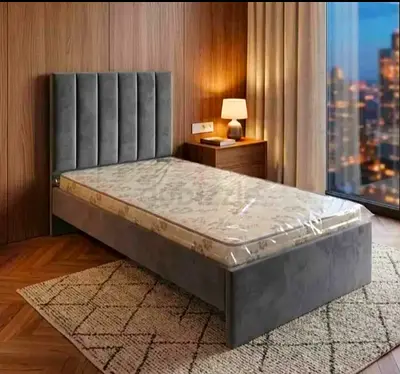 Single grey upholstered bed frame with mattress