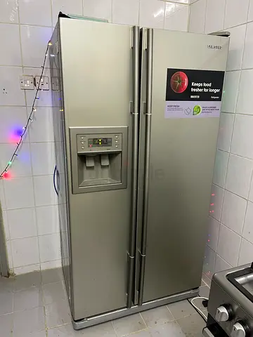 Large side-by-side stainless steel refrigerator with water dispenser - used