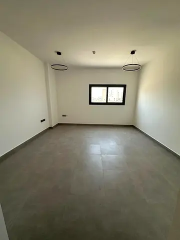 Largest and most beautiful two-bedroom apartment with a living room, brand new, for annual rent in Sharjah, Tilal City, near Victoria International Sc