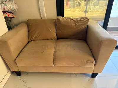 Two-seater beige fabric sofa — good condition