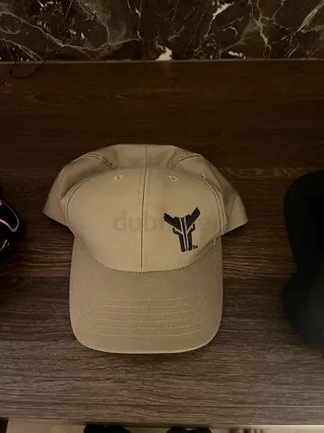 Beige baseball cap with small black plane logo - gently used