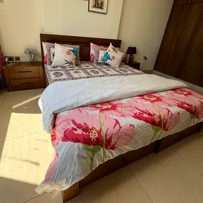 Solid wood double bed with storage and floral bedding