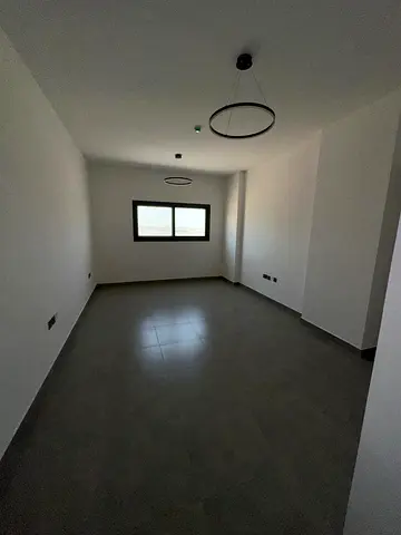1BR hall, first tenant, Tilal City Sharjah, direct Dubai exit, brand new building, 2 bathrooms, built-in wardrobes
