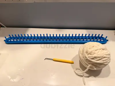Long rectangular knitting loom with hook and yarn (used)