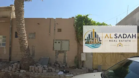 For sale: A house in Umm Khanoor, divided into two sections. The first section has 3 bedrooms, a living room, a kitchen, and 3 bathrooms. The second section has 2 bedrooms, a living room, a kitchen, a