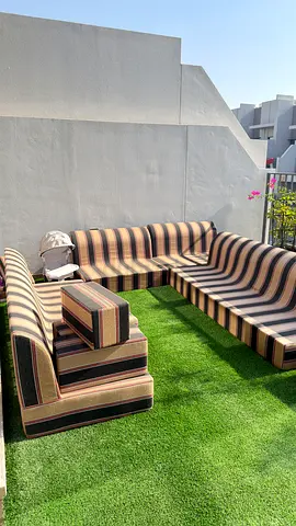 Outdoor striped seating set with cushions on artificial grass