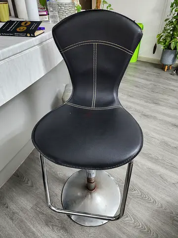 Black adjustable high chair and white steel chairs