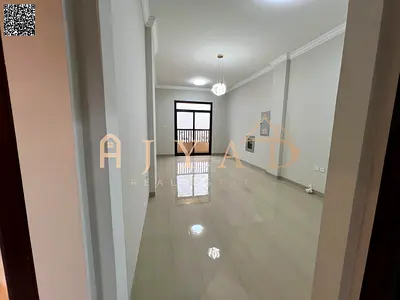 First tenant 1BR hall in Al Mowaihat 3 (Ajman). Free month, master bed, 2 baths, balcony, built-in wardrobes, central AC & gas, easy pay.