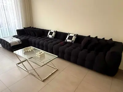 Long tufted black modular sofa with chaise