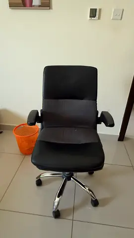 Used black ergonomic office chair with armrests and wheels