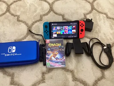 Nintendo Switch OLED with Joy-Cons, case, charger, controller grip and Crash Bandicoot game