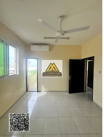 Two-bedroom apartment with a living room in Al Rawda 1, Ajman, separated by a door, 2 bathrooms, balcony, split AC, prime location near Dubai, AED 34,
