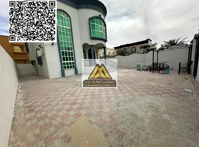Villa for rent in Al Rawda 3, Ajman, corner location with large green spaces, consisting of 5 rooms, a living room, a majlis, and a spacious yard. Sui