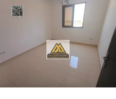 One-bedroom apartment with hall in Al Alia, Ajman, 2 bathrooms, central AC. 29,000 yearly, 4 payments. Prime location on Sharjah & Dubai exit, close t