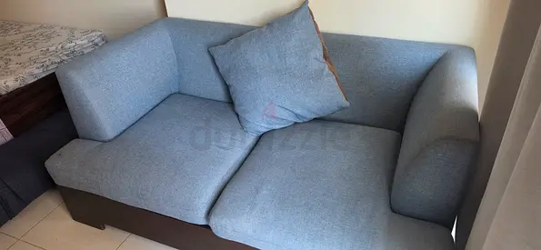 Two-seater light blue fabric sofa in good condition