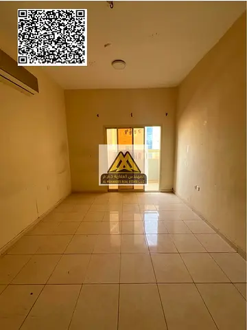 A 1-bedroom apartment with a living room for annual rent in Al Nuaimiya 2 – Ajman, featuring a spacious layout, closed kitchen, balcony, and split AC,