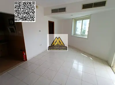 A studio for annual rent in Al Rashidiya 3 – Ajman, featuring a balcony, built-in wardrobes, a separate kitchen, and central AC in a prime location cl