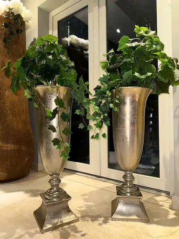 Pair of tall metallic decorative vases with faux plants