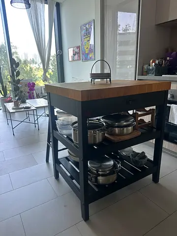 Kitchen island cart with wooden top and storage shelf and 2 wooden stools.
