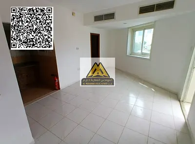 A studio for annual rent in Al Rashidiya 3 – Ajman, featuring a balcony, built-in wardrobes, a separate kitchen, central AC, and free maintenance, loc