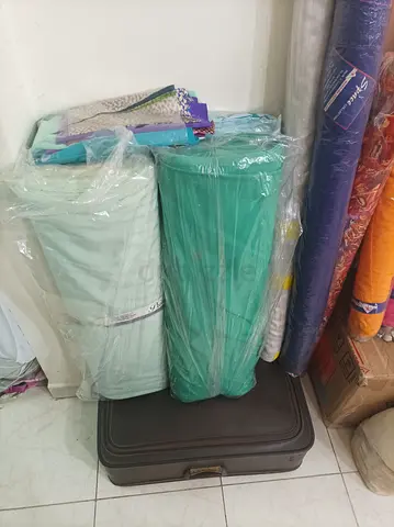 The items shown are large rolls of textile fabrics, commonly used for making clothing, drapery, or u