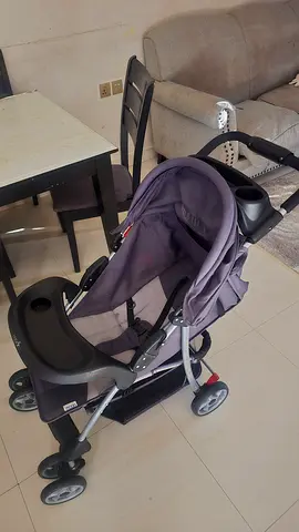Lightly used grey standard baby stroller with cup holders and storage basket