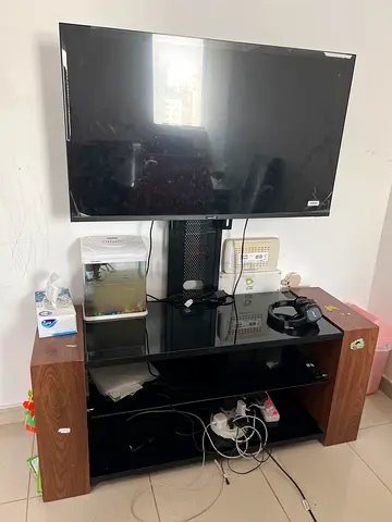 Used wall-mounted flat panel Smart TV with stand and accessories