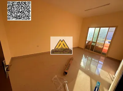 A clean and spacious 1-bedroom apartment with a living room for annual rent in Al Nuaimiya – Ajman, featuring a balcony and central air conditioning,