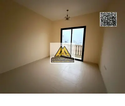 One-bedroom apartment with living room in Al Alia, Ajman, first tenant, 2 bathrooms, balcony, new central AC, prime location near Sheikh Mohammed Bin