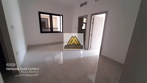 One-bedroom apartment with hall in Al Alia, Ajman, 2 bathrooms, large space, central AC. 29,000 yearly, 4 payments. Prime location on Sharjah & Dubai