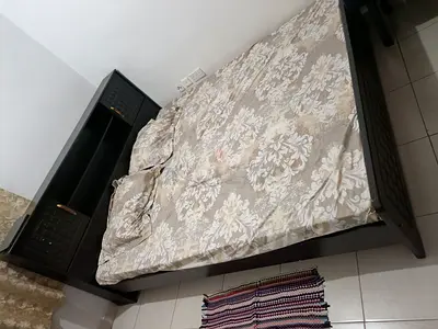 Dark wood double bed with headboard and storage shelves